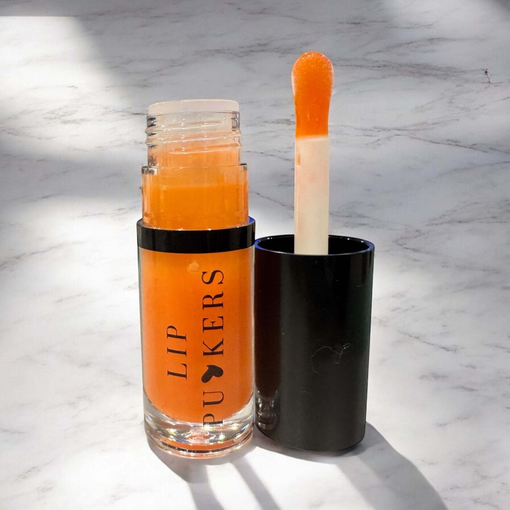 Amber Bloom Nourishing Lip Oil bottle with jojoba, apricot, and vitamin E for glossy, hydrated lips without grease